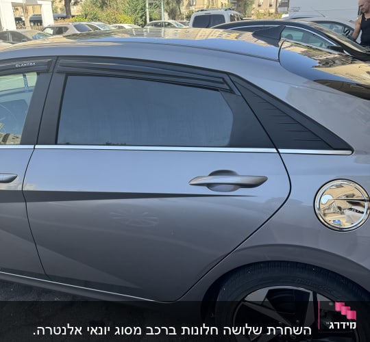 מכונית אפורה עם חלונות כהים וחישוקי גלגלים שחורים
